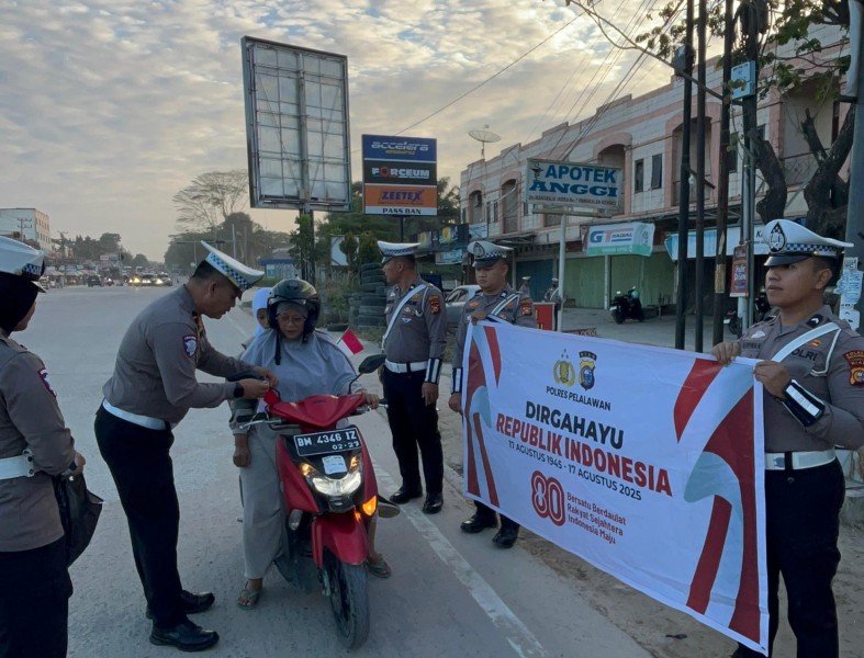Satlantas Polres Pelalawan Tebar Semangat Proklamasi, Bagikan Ratusan Bendera Merah Putih di Jalan Lintas Timur