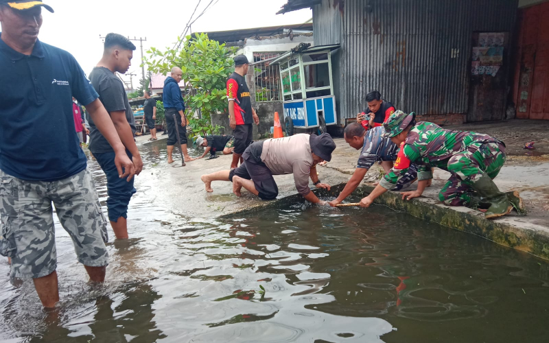 Banjir Mulai Surut, Babinsa Bersama Warga dan Damkar Bersihkan Sampah di Jalan Hangtuah