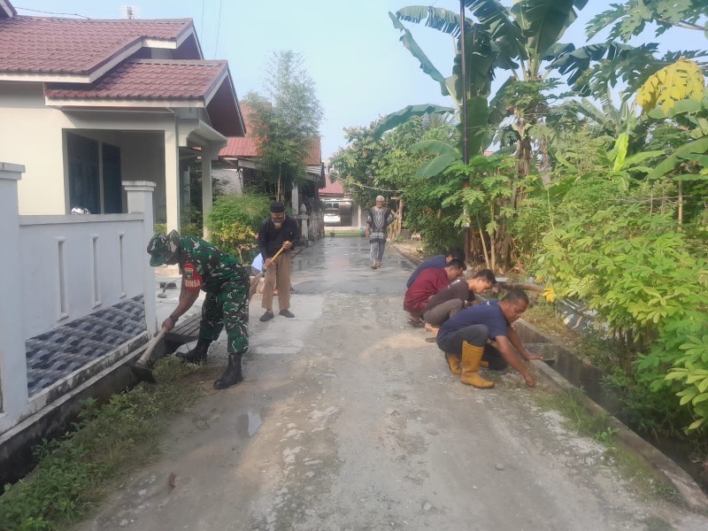 Babinsa Sertu Venus Luberto Pimpin Gotong Royong Bersihkan Parit dan Jalan di Perawang Barat