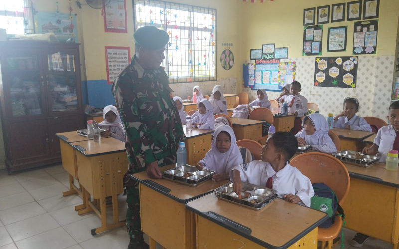 Dukung Pemenuhan Gizi Anak, Babinsa Koramil 01 Kawal Pembagian Makanan Bergizi