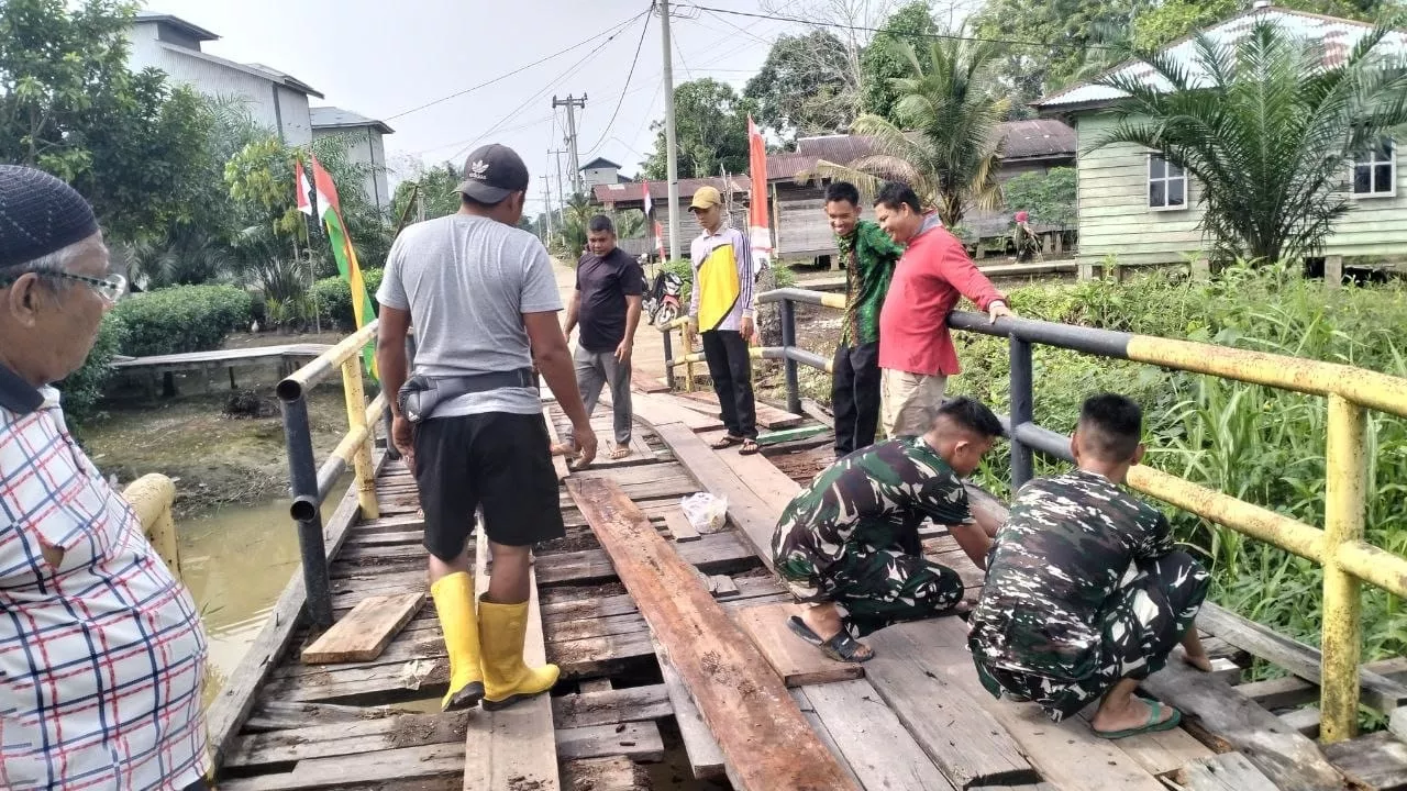 Perkuat Kemanunggalan TNI dan Rakyat, Satgas TMMD ke-129 Kodim 0313/KPR dan Warga Gotong Royong Perbaiki Jembatan jalan Desa.
