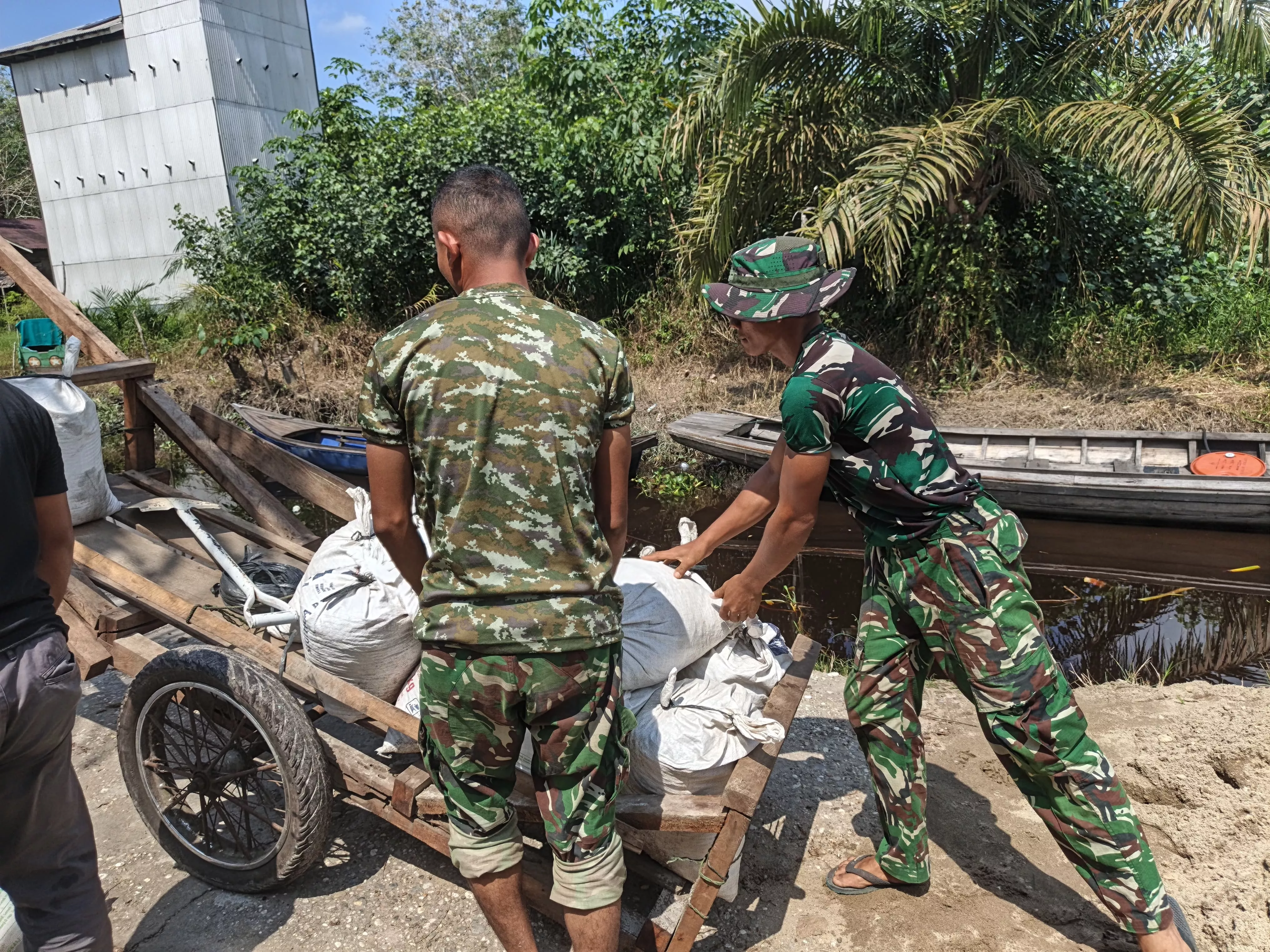 Tembus Jalan Sejauh 1,5 KM Dengan Gerobak Sorong, Satgas TMMD KODIM 0313/KPR Kucurkan Keringat Langsir Material Ke Rumah Ibu Diasan