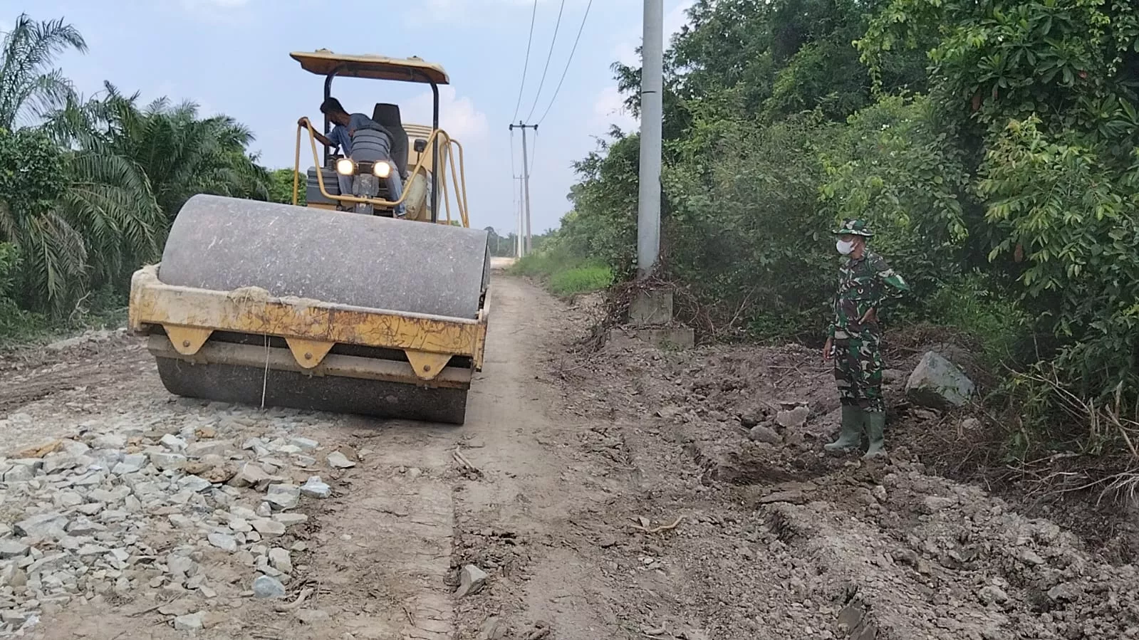 Tutup Jalan Berlubang dan Merapikan Bahu Jalan, Satgas TMMD ke-129 Kodim 0313/KPR Dipacu Hingga Jembatan T. Tahal