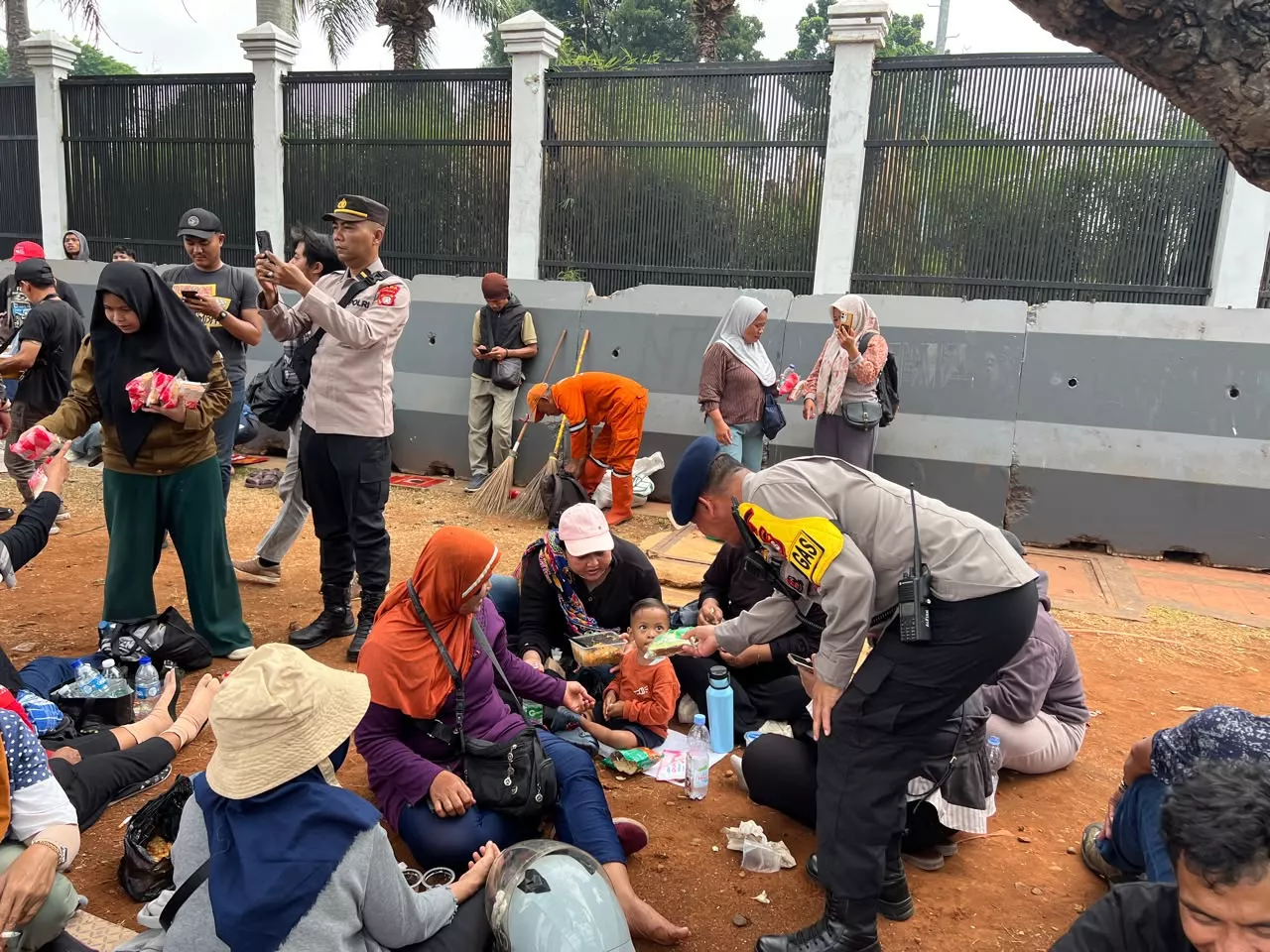 Brimob dan Polwan Polda Metro Bagikan Roti untuk Massa Hari Tani