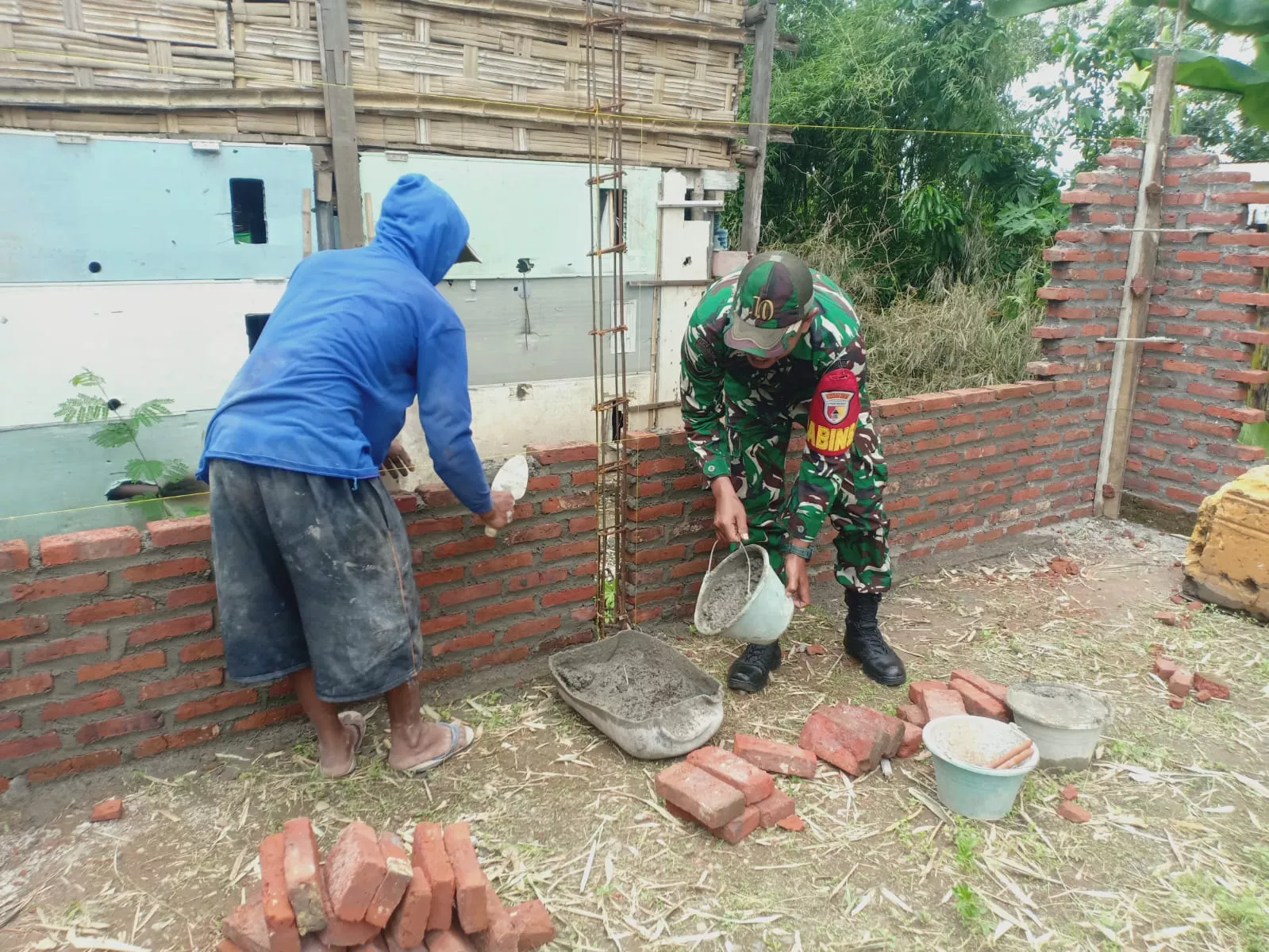 Babinsa Mojoagung Bantu Warga Kerjakan Pondasi Rumah di Desa Seketi