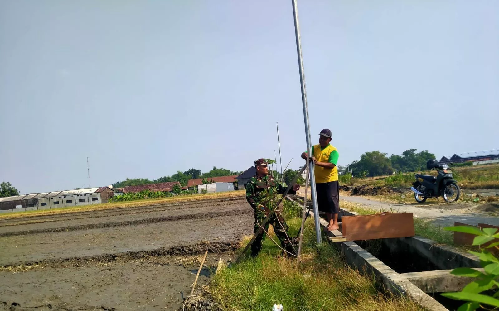 Babinsa Koramil Sumobito Bantu Warga Pasang Lampu di Desa Palrejo