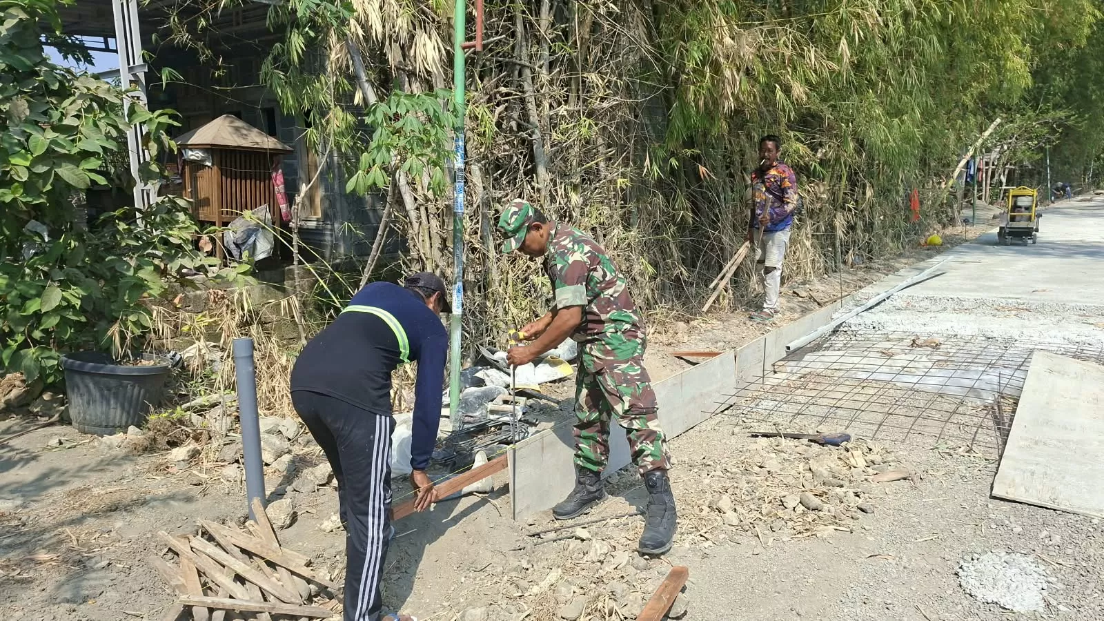 Babinsa Koramil Ploso dan Warga Jatibanjar Gelar Kerja Bakti Bersihkan Irigasi hingga Jalan
