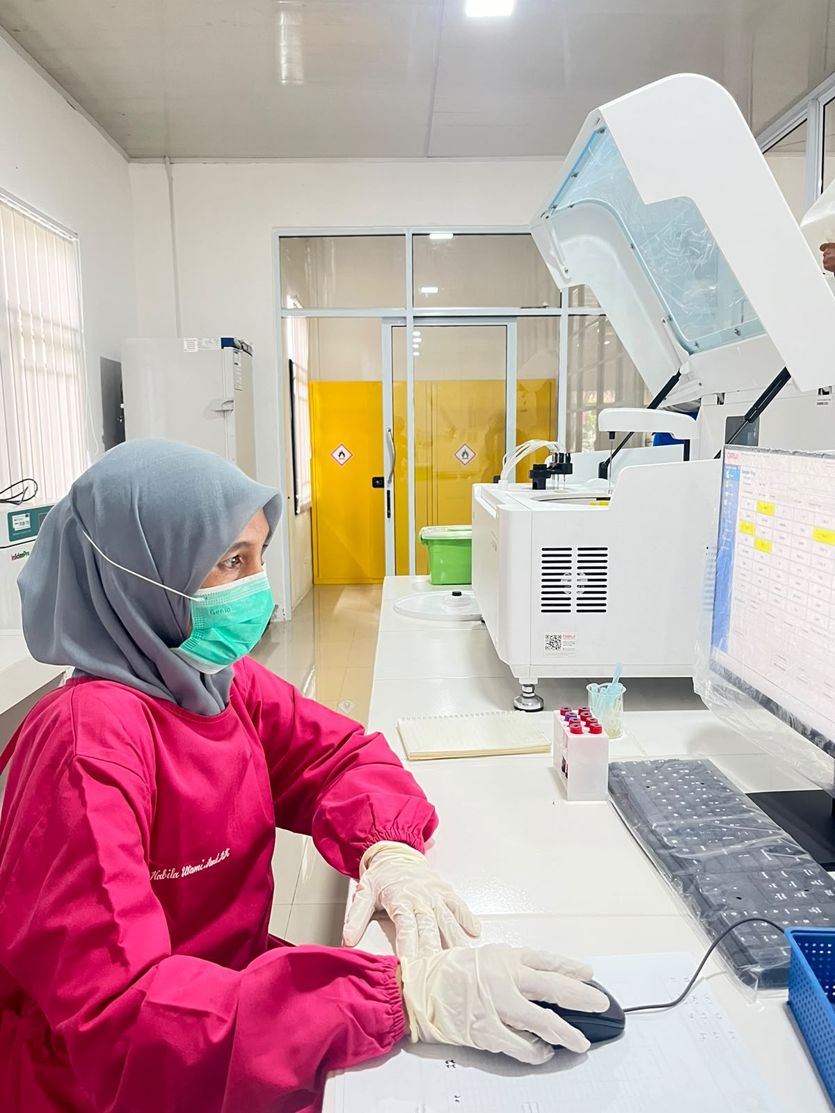 Analis laboratorium kesehatan melakukan pemeriksaan sampel dengan mikroskop